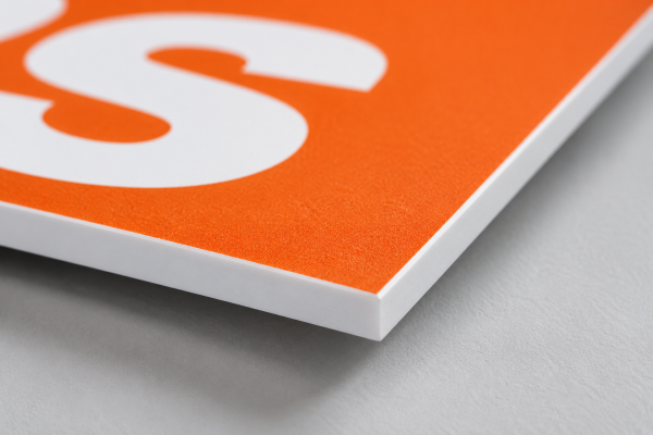 Close-up of the smooth, solid white cut edge on a custom printed PVC sign